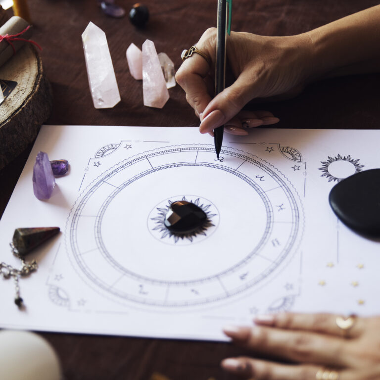 A woman fills in the zodiac symbols in a person's birth chart on